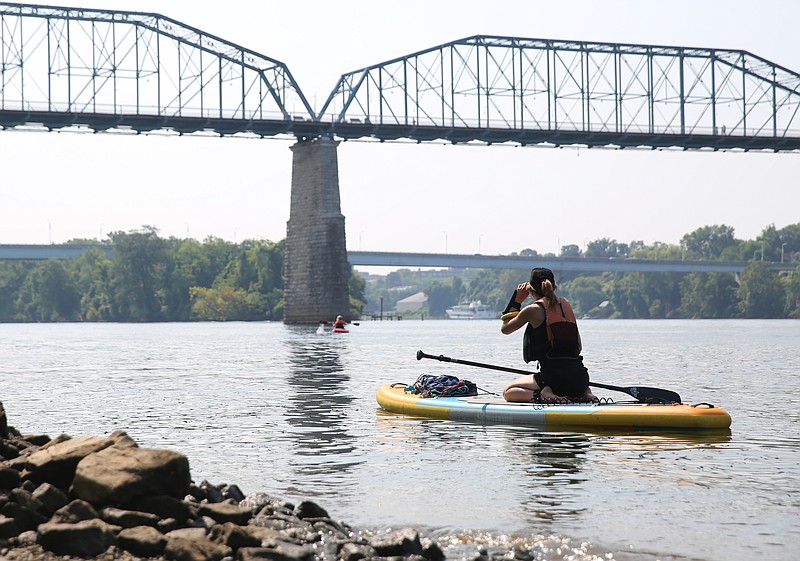 VML Art Director Mars Denton paddle boards Thursday, July 20, 2017, on the Tennessee River at the Market Street Bridge in Chattanooga, Tenn. A group of three from VML went paragliding, bouldering, slacklining, paddleboarding, kayaking, climbing and mountain biking during a visit to Chattanooga. 