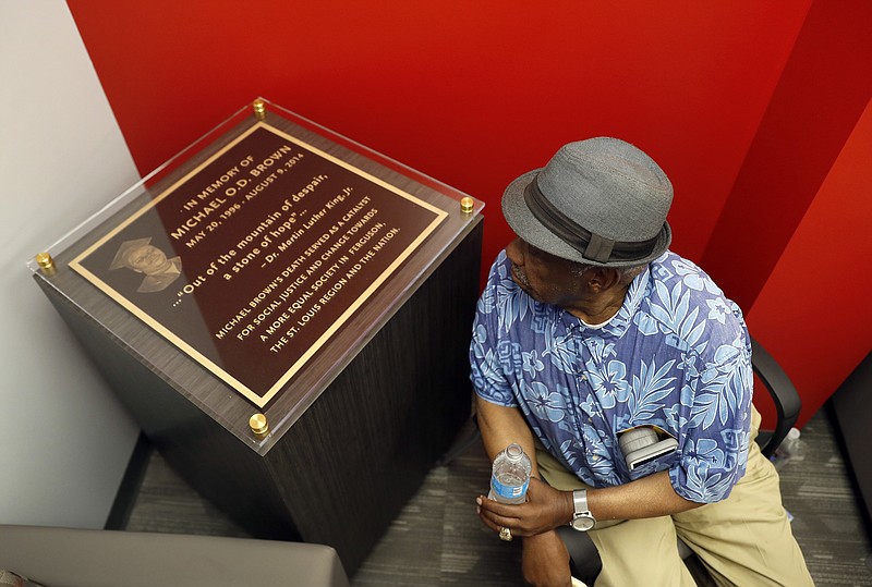 
              Martin L. Mathews, co-founder of St. Louis' Mathews-Dickey Boys' & Girls' Club, pauses to read a plaque in memory of Michael Brown during the dedication of a new community empowerment center Wednesday, July 26, 2017, in Ferguson, Mo. The $3-million Ferguson Community Empowerment Center was built on the property where a QuikTrip convenience store was burned during rioting after a white officer fatally shot Michael Brown nearly three years ago. (AP Photo/Jeff Roberson)
            