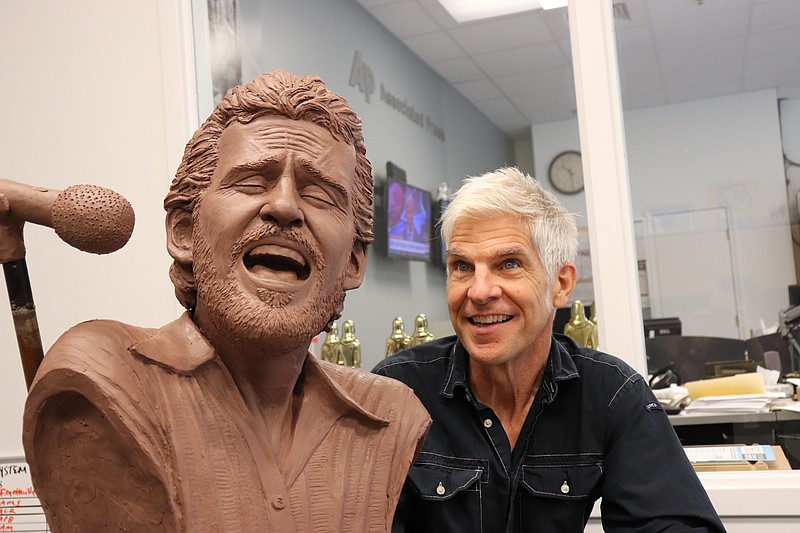 
              Sculptor Kevin Kresse appears with a bust he created of the late musician Levon Helm, Wednesday, July 26, 2017, in Little Rock, Ark. The bust, once bronzed, will be part of a memorial to the performer, who grew up near Turkey Scratch in eastern Arkansas. (AP Photo/Kelly P. Kissel)
            