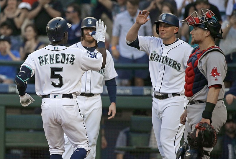 
              Seattle Mariners' Guillermo Heredia (5) is greeted at the plate as Boston Red Sox catcher Christian Vazquez watches after Heredia hit a three-run home run during the second inning of a baseball game Tuesday, July 25, 2017, in Seattle. (AP Photo/Ted S. Warren)
            