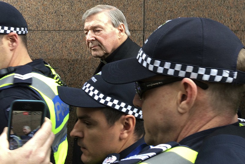 
              Cardinal George Pell, rear center, Australia's highest-ranking Catholic and Pope Francis' top financial adviser, leaves Melbourne Magistrates' Court Wednesday, July 26, 2017. Pell, the most senior Vatican official ever charged in the Catholic Church sex abuse crisis, made his first court appearance in a scandal that has stunned the Holy See and threatened to tarnish the pope's image as a crusader against abusive clergy. (AP Photo/Kristen Gelineau)
            