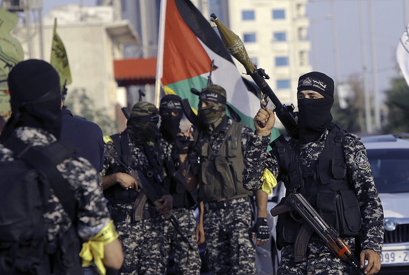 
              Masked militants from Nabil Masoud Brigades, a military wing of the Fatah movement, hold their weapons during a parade against Israeli arrangements in a contested Jerusalem shrine, along the streets of Gaza City, Tuesday, July 25, 2017. Muslim leaders urged the faithful Tuesday to keep up their prayer protests and avoid entering a contested Jerusalem shrine, even after Israel dismantled metal detectors that initially triggered the tensions. (AP Photo/Adel Hana)
            