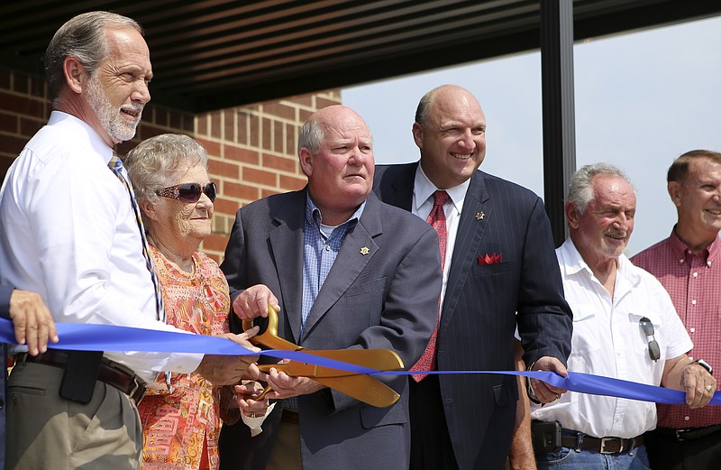 Bradley County Sheriff's Office Chief Deputy Brian K. Smith, third from the left, cuts the ribbon on the new inmate workhouse named in his honor on Thursday, July 27, in Cleveland, Tenn. The new inmate workhouse allows low-security inmates the opportunity to work in the community while still serving their time.