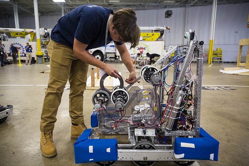 STEM School student Noah Pierce adds a bit of tape to his team's robot before demonstrating its operation at the EPB Robo Expo held at their downtown operations center on Wednesday, Sept. 5, 2016, in Chattanooga, Tenn. The robot, which was controlled remotely, could navigate obstacles and toss a foam ball into a wooden goal structure. The expo featured teams of area robotics students exhibiting robots that they built for competition.