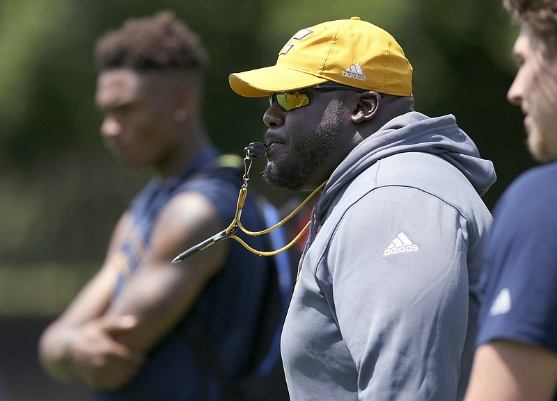 UTC tackles and tight ends coach Chris Cook looks on as players run a drill Monday during the first day of preseason practice at Scrappy Moore Field.