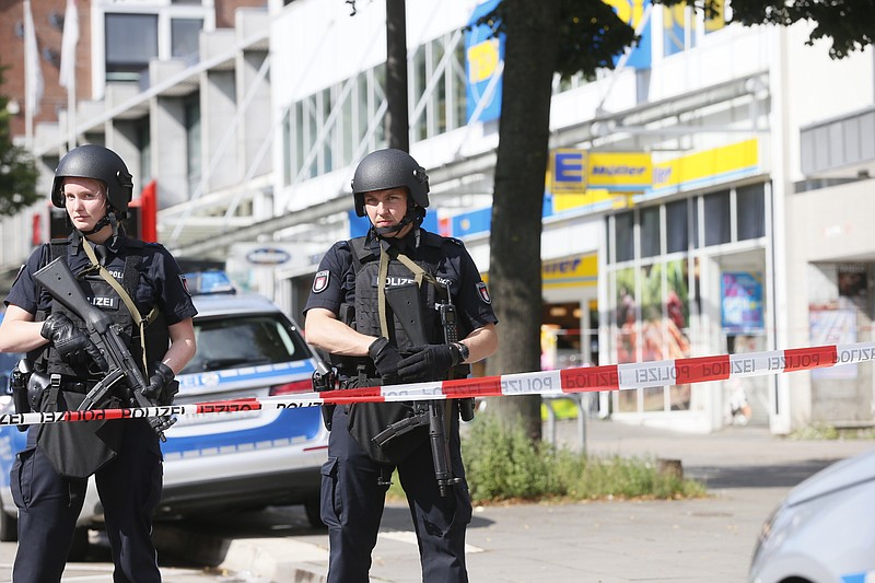 
              Police officers secure the area after a knife attack at a supermarket in Hamburg, Germany, Friday, July 28, 2017. German police say one person died and several people suffered stab wounds. (Paul Weidenbaum/dpa via AP)
            