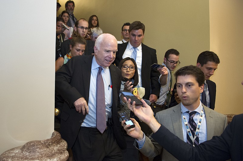 Sen. John McCain, R-Az., front left, is pursued by reporters after casting a 'no' vote on a a measure to repeal parts of former President Barack Obama's health care law, on Capitol Hill in Washington, Friday, July 28, 2017. (AP Photo/Cliff Owen)
