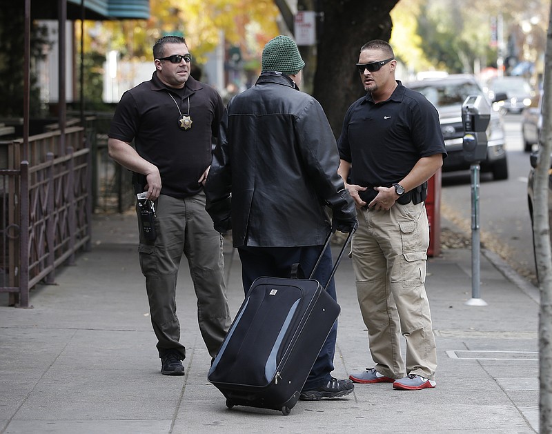 
              FILE -- In this Dec. 1, 2015 file photo, parole agents Andrew Correa, left, and Clint Cooley, right, talk with a sex-offender parolee they located by tracking the global positioning device he wears, in Sacramento, There are as many homeless sex offenders in California now as 2½ years ago when a state Supreme Court ruling that overturned restrictions on where they can live was seen as a way to increase housing options and allow law enforcement to better track them.  (AP Photo/Rich Pedroncelli, file)
            