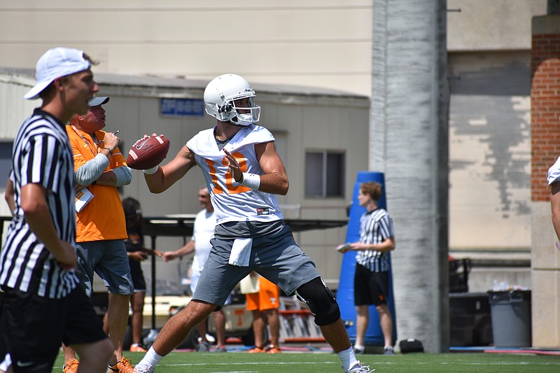 Tennessee quarterback Quinten Dormady throws a pass during Tennessee's first preseason practice on July 29 as head coach Butch Jones watches.