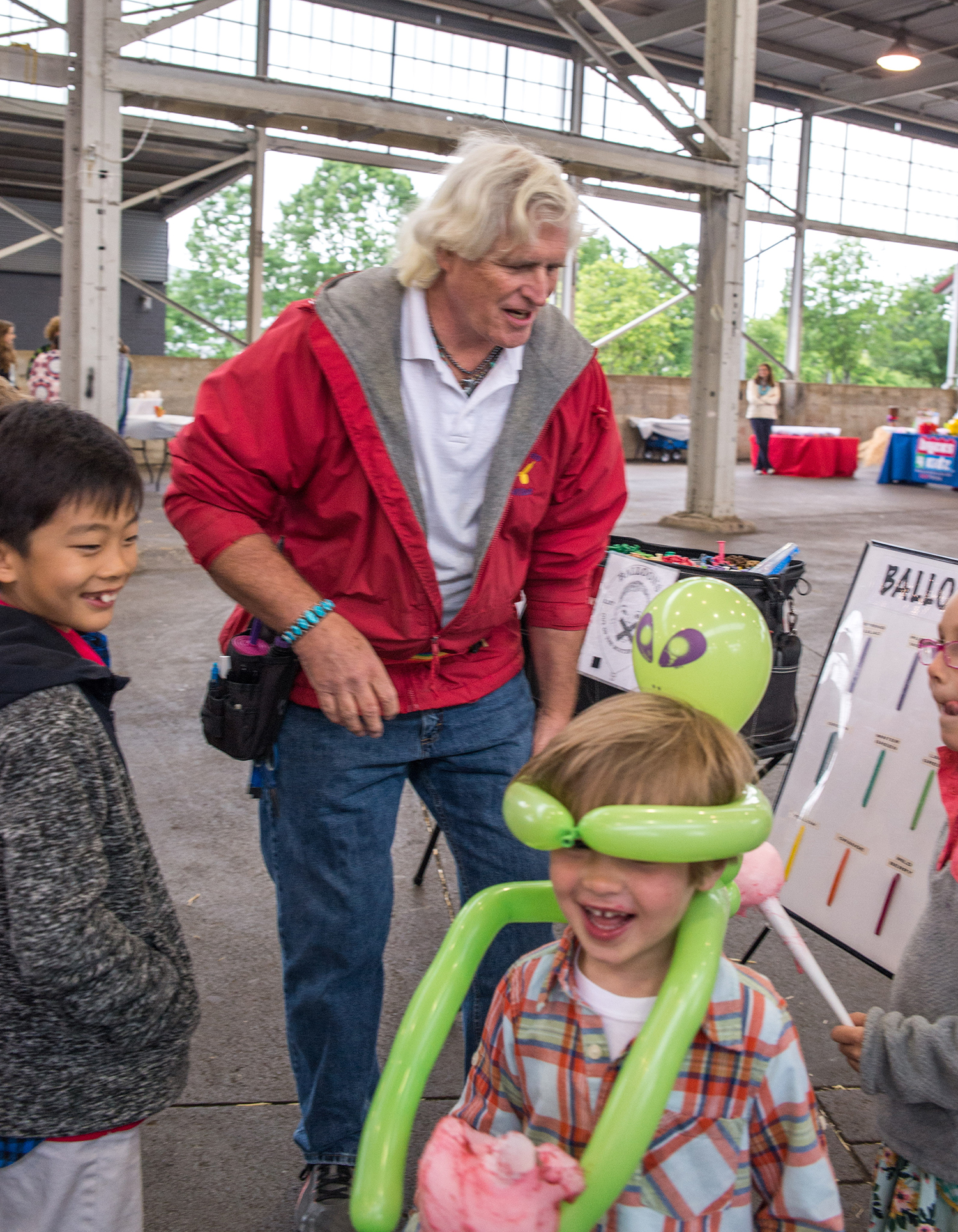 Ballon artist Mike Edwards puts a balloon on Will Prentice head