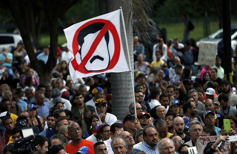
              An anti-government demonstrator waves a flag against Venezuela's President Nicolas Maduro during a vigil in honor of those who have been killed during clashes between security forces and demonstrators in Caracas, Venezuela, Monday, July 31, 2017. Many analysts believe Sunday's vote for a newly elected assembly that will rewrite Venezuela’s constitution will catalyze yet more disturbances in a country that has seen four months of street protests in which at least 125 people have died. (AP Photo/Ariana Cubillos)
            