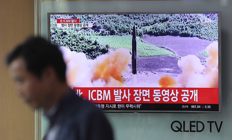 A man at the Seoul Train Station in South Korea walks by a TV screen last month during a local news program reporting about North Korea's missile firing. (AP Photo/Lee Jin-man)