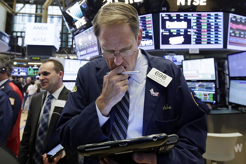 Trader Luke Scanlon, center, works on the floor of the New York Stock Exchange, Tuesday, Aug. 1, 2017. More solid earnings reports from U.S. companies are sending stocks higher in early trading on Wall Street. (AP Photo/Richard Drew)