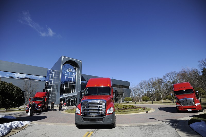 Three trucks are parked outside the U.S. Xpress Enterprises building in Chattanooga