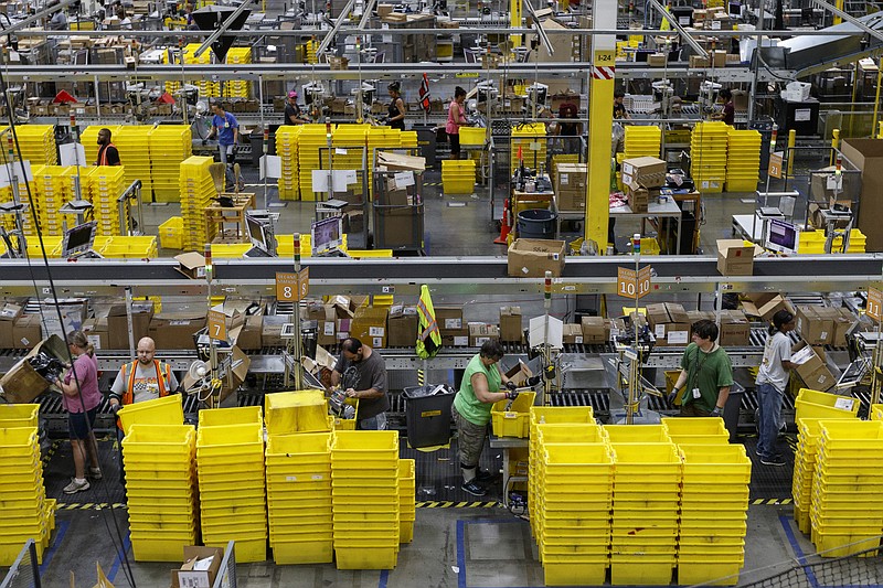 Workers unpack items shipped from affiliates to the Amazon Fulfillment Center in Enterprise South Industrial Park on Wednesday, Aug. 2, 2017, in Chattanooga, Tenn. Amazon held nationwide job fairs Wednesday to fill 50,000 positions as the company sees a surge in growth.