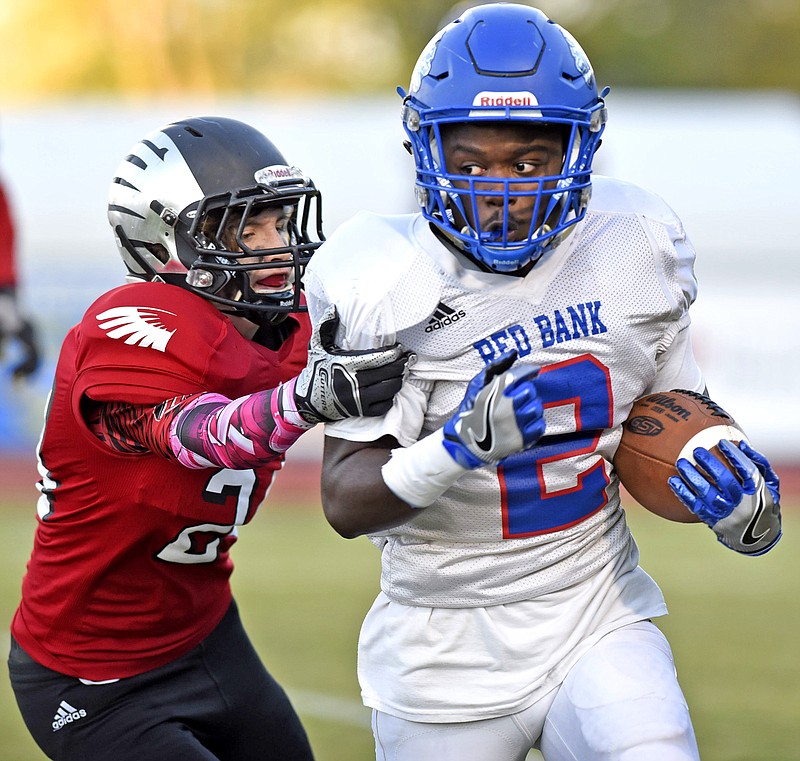 Red Bank running back Zay Brown breaks a tackle attempt by Signal Mountain's Campbell Garner during a game last September.