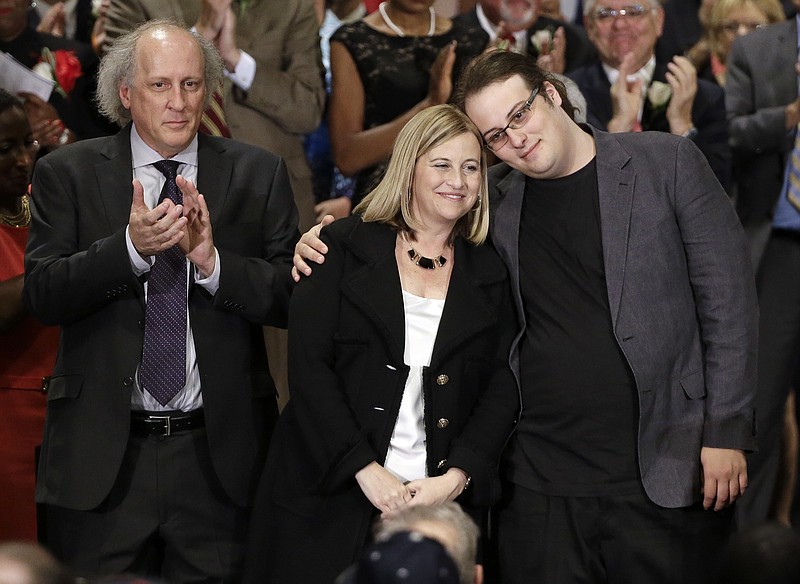 In this Sept. 25, 2015, photo, Nashville Mayor Megan Barry, center, is hugged by her son, Max, as her husband, Bruce, left, applauds after she was sworn into office in Nashville, Tenn. A statement released Sunday, July 30, 2017, from Megan and Bruce Barry, said their only child, Max Barry, died Saturday night in Denver from an apparent drug overdose. (AP Photo/Mark Humphrey, File)