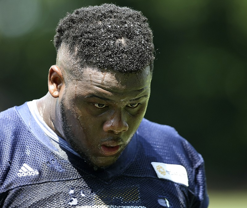 Water runs down UTC defensive lineman Derek Mahaffey's face during the first day of fall practice at Scrappy Moore Field on Monday, July 24, in Chattanooga, Tenn.