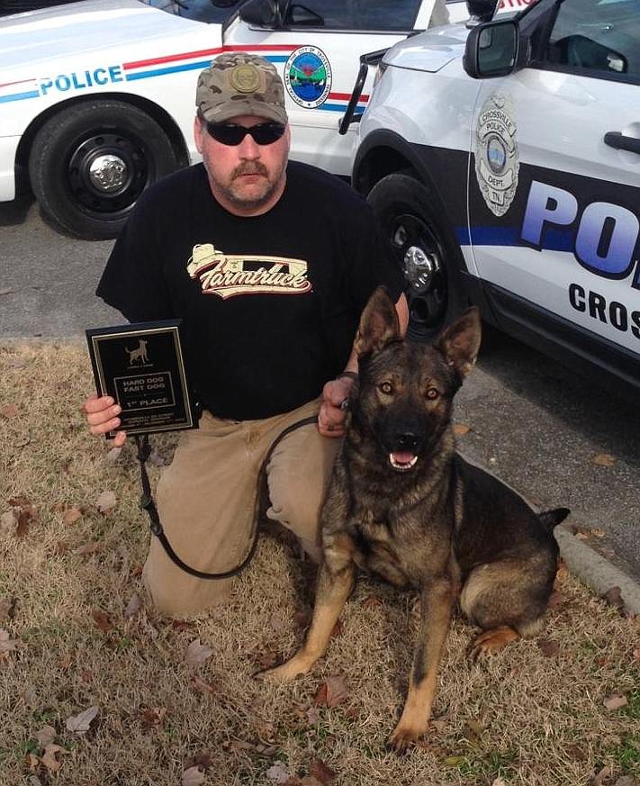 Crossville Police Lt. Bart Riden kneels with his K-9 partner, Cain. The dog died Wednesday from stab wounds sustained in pursuit of a fleeing suspect.