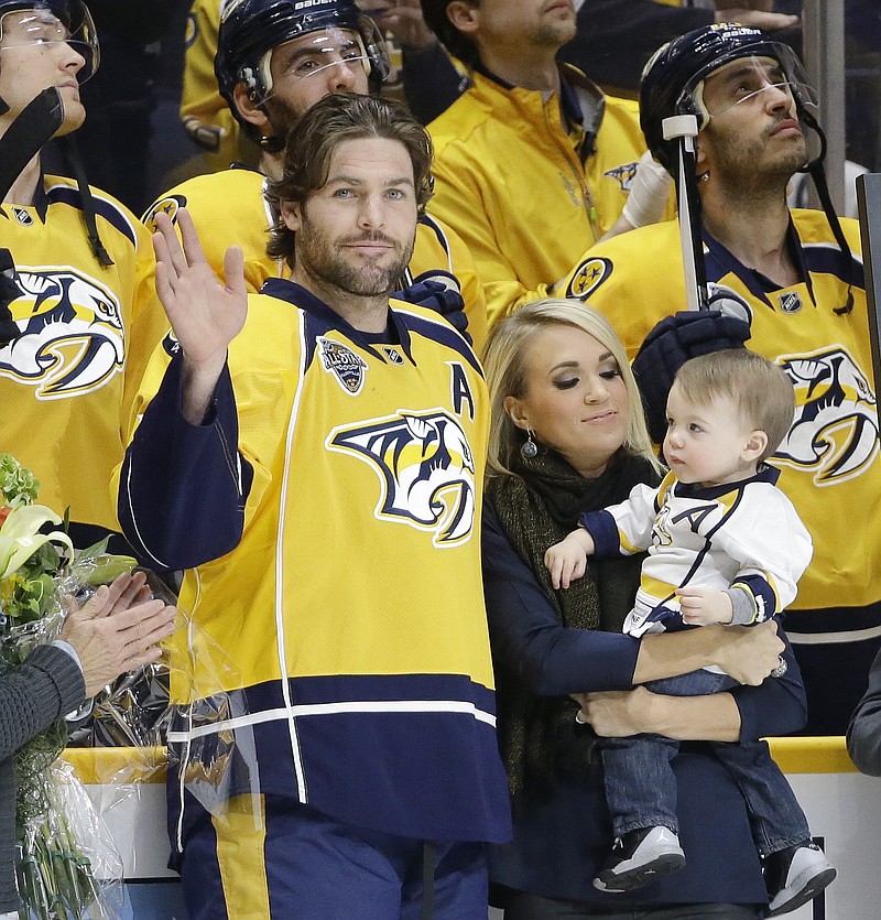 
              FILE - In this March 21, 2016, file photo, Nashville Predators forward Mike Fisher is honored for his 1,000th NHL hockey game before the first period of a game against the Los Angeles Kings, in Nashville, Tenn. With Fisher is his wife, singer Carrie Underwood, and their son, Isaiah. Mike Fisher has announced his retirement, a move that means the defending Stanley Cup finalists must select a new captain. Fisher, 37, said in a letter to Predators fans that "this is the hardest decision that I've ever had to make, but I know I've made the right one."(AP Photo/Mark Humphrey, File)
            