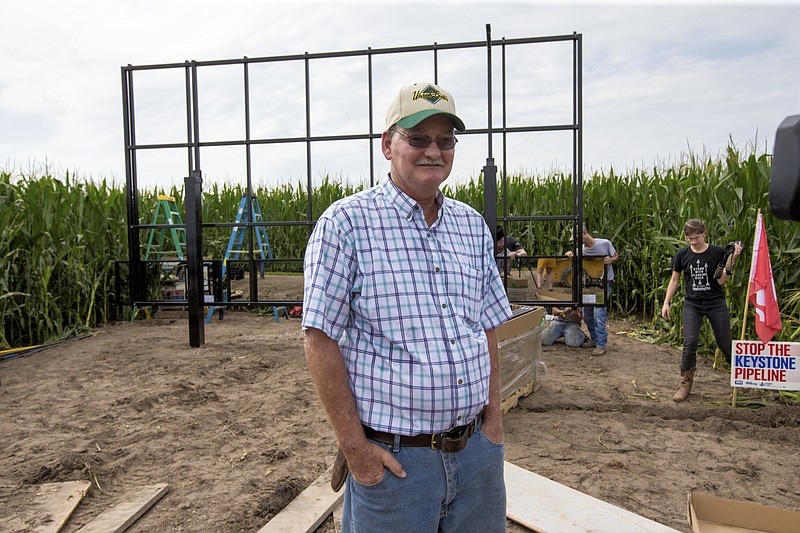 
              In this July 29, 2017 photo, corn farmer Jim Carlson of Silver Creek, Ne., waits to be interviewed by a television reporter while standing in front of solar panels he is building on his land in the proposed path of the Keystone XL pipeline. Despite new uncertainty over whether TransCanada, the builder of the Keystone XL pipeline will continue the project, longtime opponents in Nebraska aren't letting their guard down and neither are law enforcement officials who may have to react to protests if it wins approval. (AP Photo/Nati Harnik)
            