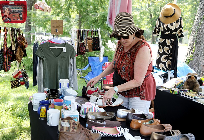Deb Shanton arranges shoes Thursday, Aug. 3, 2017, at her setup in the World's Longest Yard Sale along Highway 127 in Signal Mountain, Tenn. Shanton's neighbors have been participating in the yard sale for years, and she decided to participate this year since she was now retired.