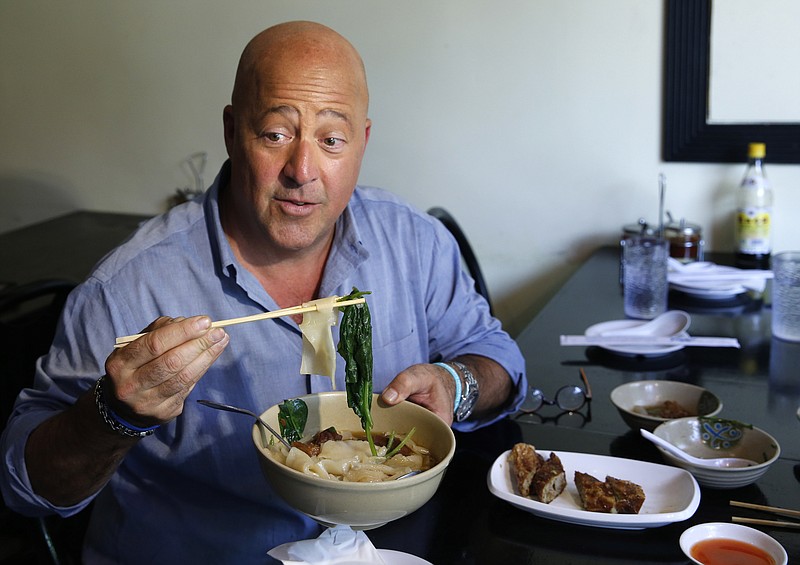 In this Thursday, July 20, 2017 photo, Travel Channel's "Bizzare Foods" host Andrew Zimmern, a four-time James Beard award-winning chef, samples Taiwanese noodle soup and pork roll at Happy Stony Noodle in Elmhurst, Queens in New York. His new show, "The Zimmern List," debuts in early 2018 showcasing his personal favorite places to eat when the cameras aren't rolling. (AP Photo/Kathy Willens)