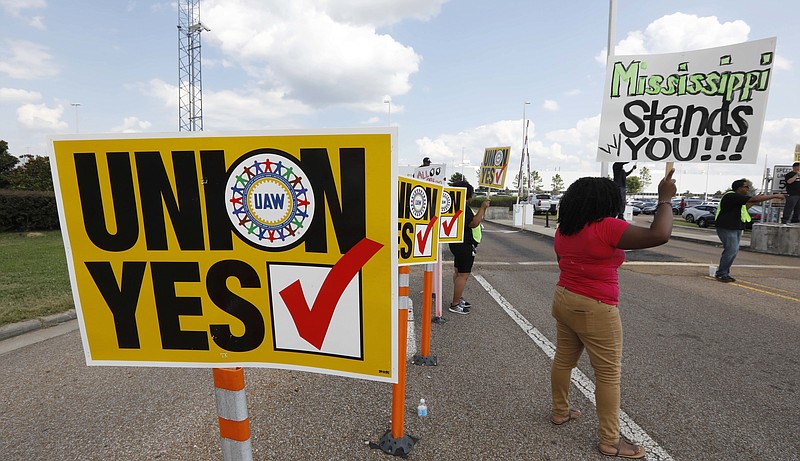 
              United Auto Workers  members and their volunteers stand outside an entrance to the Nissan vehicle assembly plant in Canton, Miss., and greet each arriving and departing vehicle, Thursday, Aug. 3, 2017. Union members set up informational lines outside employee entrances at the plant and greeted all shifts of workers reminding them to vote for the union. The vote for union representation of line workers runs Aug. 3-4. (AP Photo/Rogelio V. Solis)
            