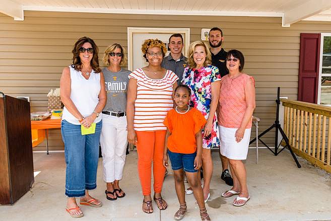 Knoxville resident Whitnee Holloway, center, was the recipient of a house from Habitat for Humanity that representatives from the Tennessee football 
program helped build.