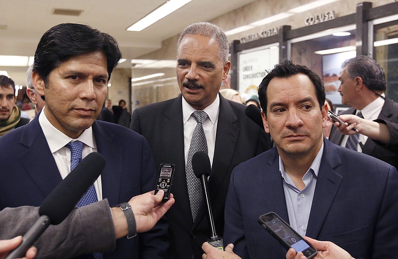 
              FILE - In this Feb. 7, 2017 file photo, former U.S. Attorney General Eric Holder, center, flanked by California Senate President Pro Tem Kevin de Leon, D-Los Angeles, left, and Assembly Speaker Anthony Rendon, D-Paramount, talks to reporters before meeting with Calif., Gov. Brown, in Sacramento, Calif. A recall effort against Rendon, a strong progressive now targeted by party activists upset that he derailed a bill seeking government-funded health care for all. Rendon said he supports single-payer health care in concept, but SB562 was "woefully incomplete." (AP Photo/Rich Pedroncelli, File)
            
