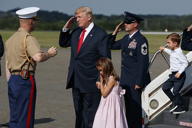 
              President Donald Trump salutes after walking down the steps of Air Force One with his grandchildren, Arabella Kushner, center, and Joseph Kushner, right, after arriving at Morristown Municipal Airport to begin his summer vacation at his Bedminster golf club, Friday, Aug. 4, 2017, in Morristown, N.J. (AP Photo/Evan Vucci)
            