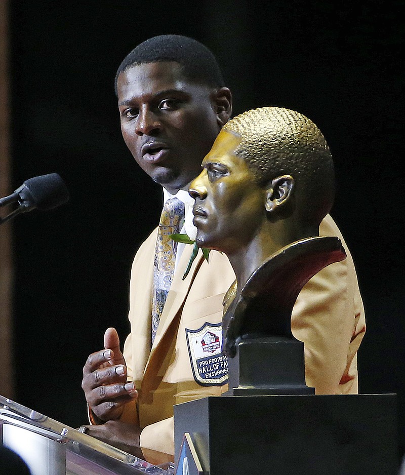 
              LaDainian Tomlinson speaks next to a bust of him at the Pro Football Hall of Fame inductions Saturday, Aug. 5, 2017, in Canton, Ohio. (AP Photo/Ron Schwane)
            