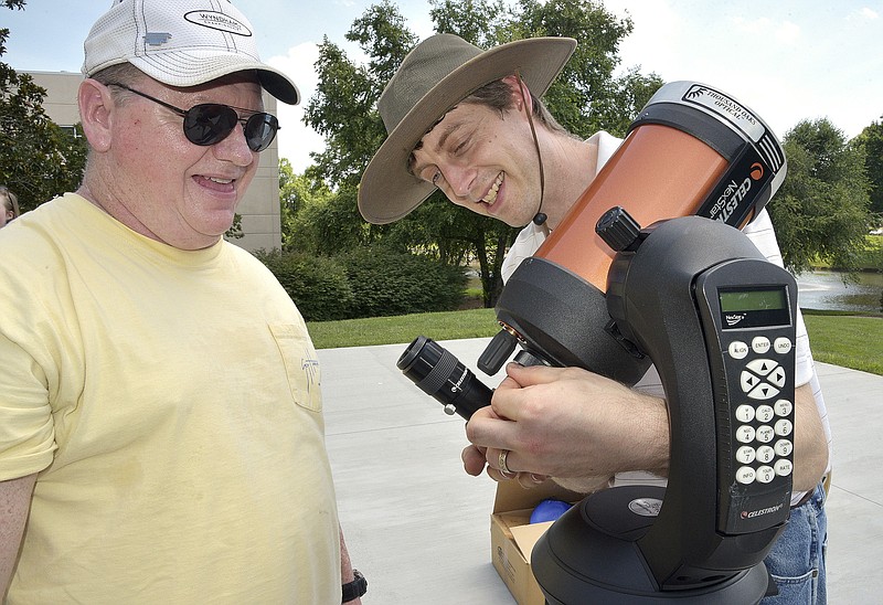
              FILE - In this June 29, 2017 file photo, David Chrismon, left, a member of Guilford Technical Community College's student astronomy club, the Stellar Society, watches as Steve Desch, an astronomy instructor, sets up a telescope in Jamestown, N.C., that the group will use on their trip to Newberry, S.C. to observe a solar eclipse on Aug. 21. (Laura Greene/The High Point Enterprise via AP)
            