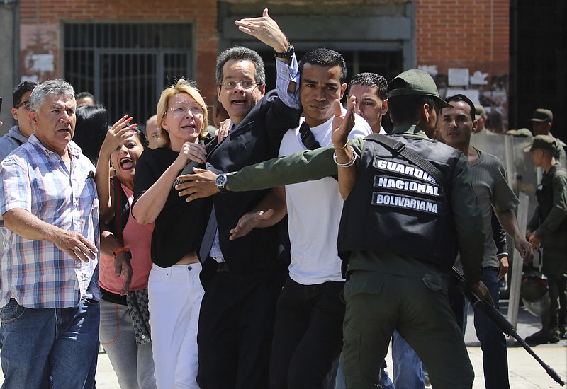 
              Venezuelan General Prosecutor Luisa Ortega Diaz, third left, is surrounded by loyal employees of the General Prosecutor's office, as she was barred from entering her office by security forces, outside of the General Prosecutor headquarters in Caracas, Venezuela, Saturday, Aug. 5, 2017. Security forces surrounded the entrance ahead of a session of the newly-installed constitutional assembly in which the pro-government body is expected to debate the onetime loyalist turned arch critic's removal. (AP Photo/Wil Riera)
            