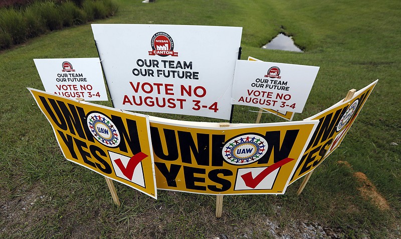 The UAW placed pro-union signs in front of anti-union signs before the vote of some 3,700 employees at the Nissan vehicle assembly plant last week in Canton, Miss.