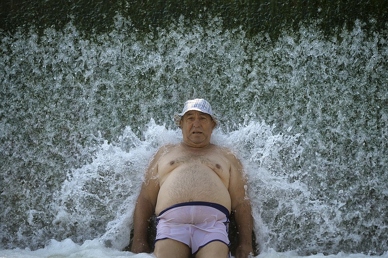 
              A man cools off in a river in Buzau, Romania, Sunday, Aug. 6, 2017. A heatwave with an extreme temperatures of up to 42 Celsius (107.6 Fahrenheit) affected Romania over the past week and is expected to continue for the coming days in parts of the country. (AP Photo/Andreea Alexandru)
            