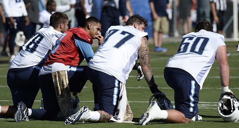 In this July 30, 2017, file photo, Tennessee Titans' Jack Conklin, left, quarterback Marcus Mariota (8), tackle Taylor Lewan (77), and center Ben Jones (60) take a break during NFL football training camp, in Nashville, Tenn. The Titans finally stabilized their offensive line in 2016 with left tackle Taylor Lewan voted to the Pro Bowl, while rookie Jack Conklin was an All Pro at right tackle. (AP Photo/Mark Zaleski, File)