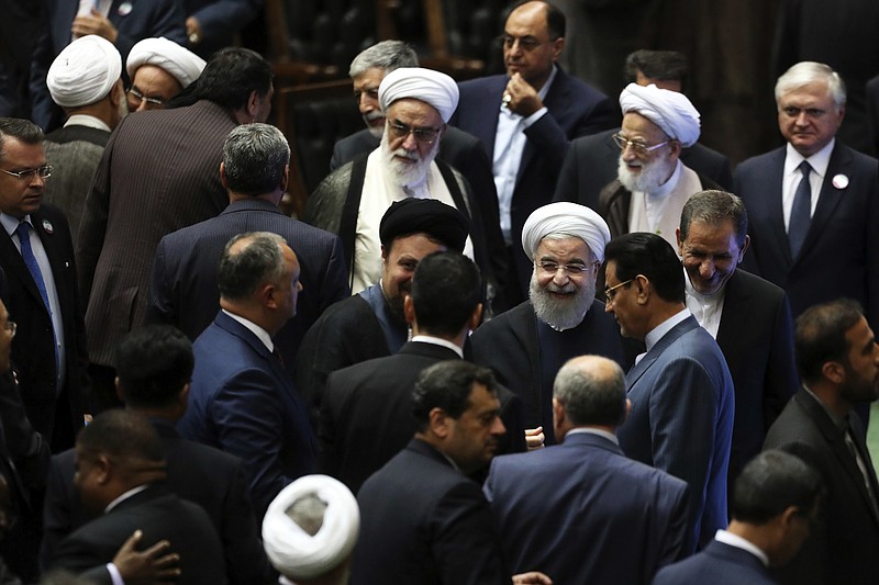 
              Iran's President Hasan Rouhani, center, leaves the parliament at the end of his swearing-in ceremony for the second term in office, in Tehran, Iran, Saturday, Aug. 5, 2017. Rouhani, 68, a moderate cleric who secured re-election on May 19, promised that his country will pursue a "path of coexistence and interaction with the world." (AP Photo/Ebrahim Noroozi)
            
