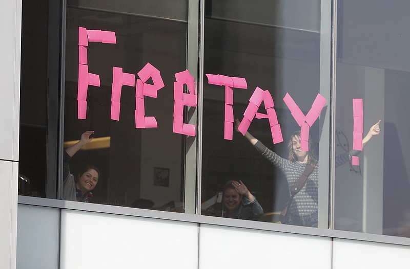 
              Workers put up sign in support of pop singer Taylor Swift in an office building across the street from the federal courthouse in Denver on Tuesday, Aug. 8, 2017, during the jury selection phase in a civil trial to determine whether a radio host groped Swift. (AP Photo/David Zalubowski)
            