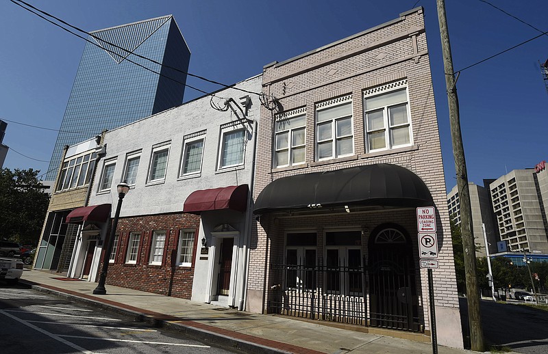 This Wednesday, July 19, 2017, photo shows a two-story brick building, right, at the northwest edge of Atlanta's old downtown. The old building is where the first country music hit was recorded in 1923 by Fiddlin' John Carson. It faces the threat of demolition to make way for a Jimmy Buffett's Margaritaville restaurant. (AP Photo/Mike Stewart)