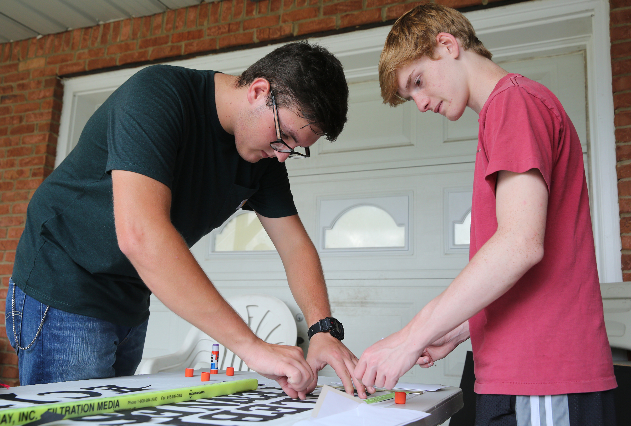 Cousins, Matthew Burkhart, 16, and Hunter Esch, 14, work on a banner at their grandparents' house Tuesday, Aug. 8, 2017, in Soddy-Daisy, Tenn. The two were preparing decorations and souvenirs for guests who attend their grandmother's Great American Eclipse party next week.
