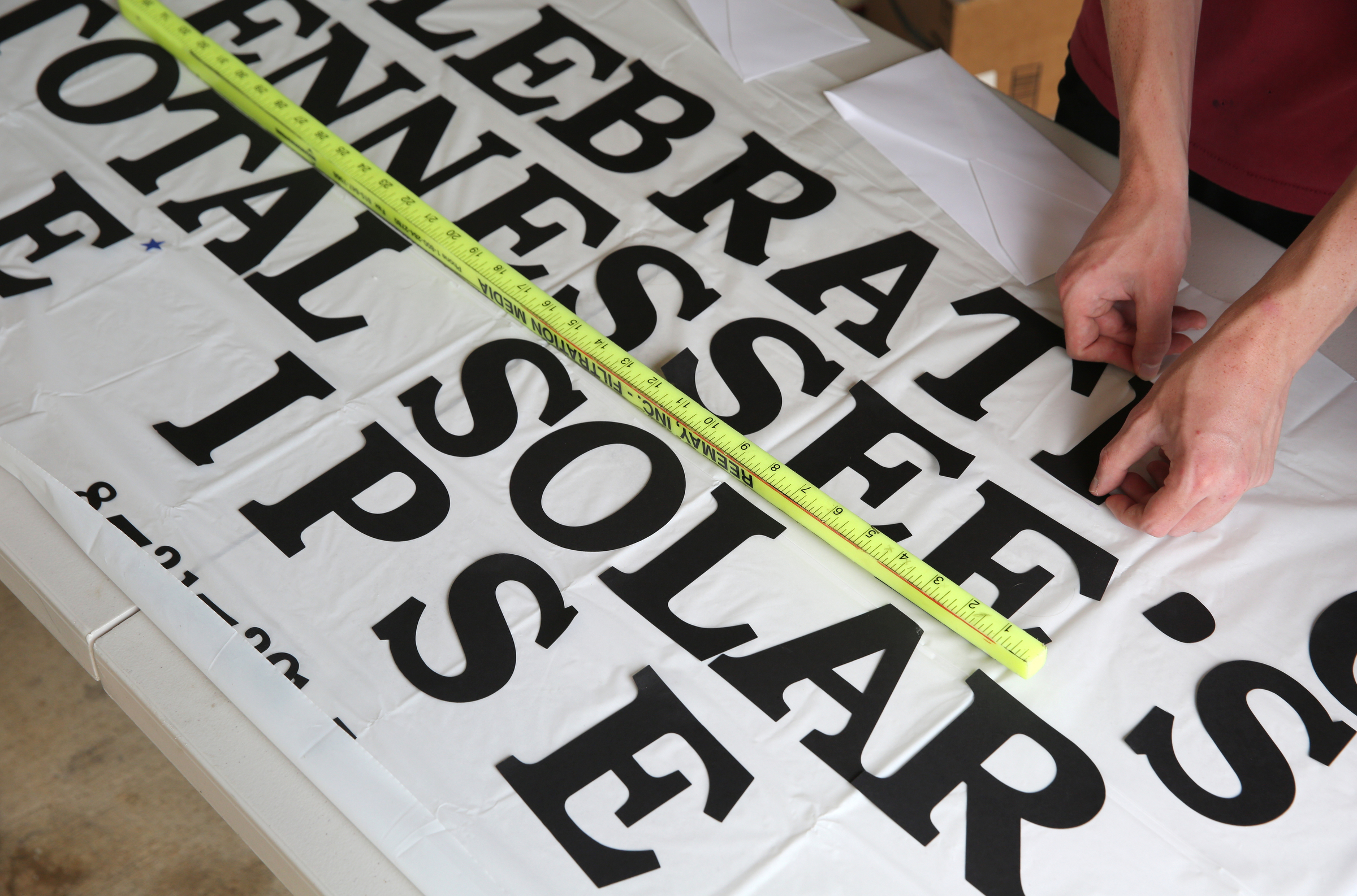 Hunter Esch works on a banner at his grandparents' house Tuesday, Aug. 8, 2017, in Soddy-Daisy, Tenn. The family was working on several projects for the eclipse party, which included decorating a banner to go around the pool, art supplies for chalk drawings and stuffing treat bags.