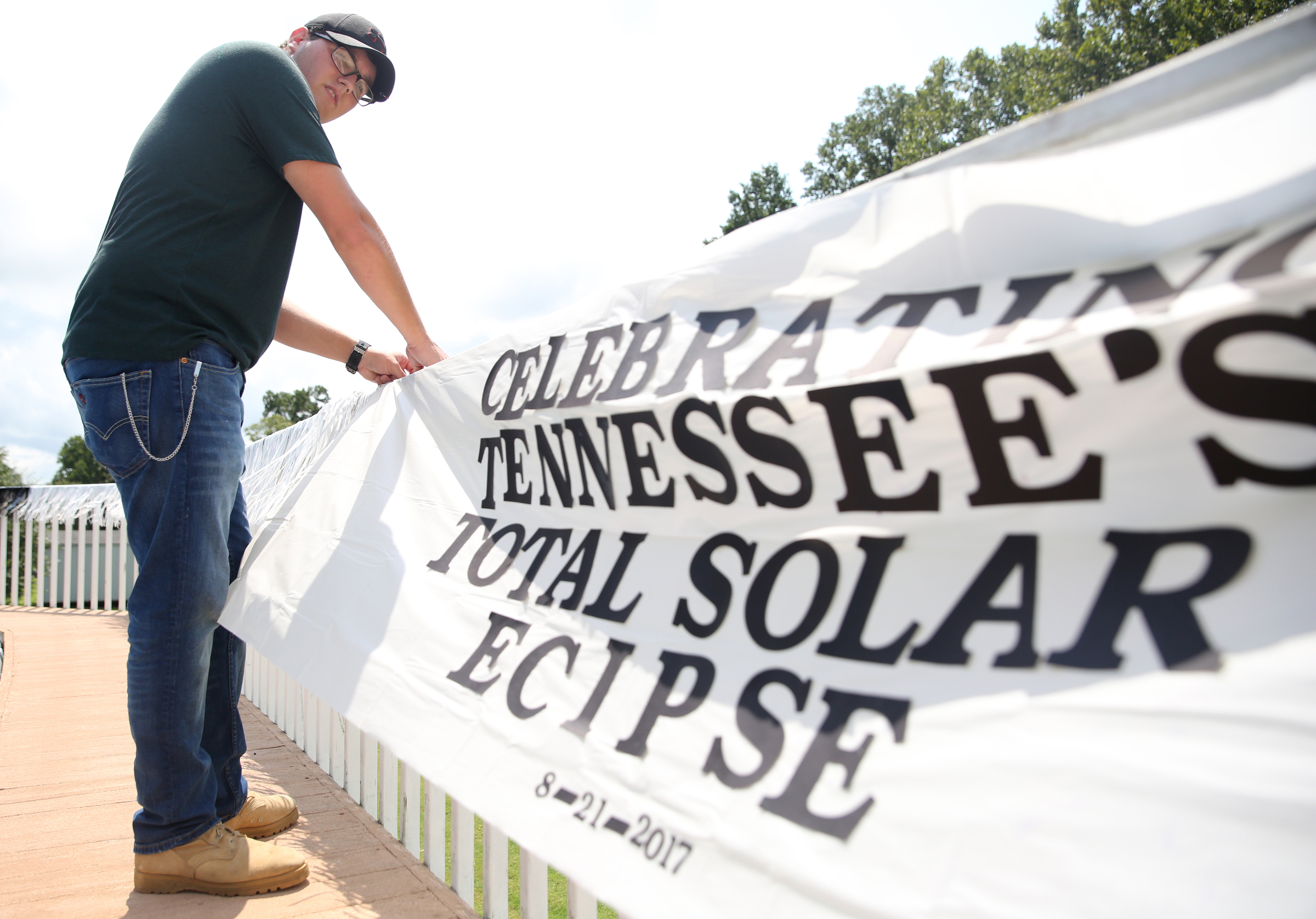 Matthew Burkhart, 16, puts up a banner at his grandparents' house Tuesday, Aug. 8, 2017, in Soddy-Daisy, Tenn. Burkhart, his cousins and grandmother were preparing decorations and souvenirs for guests who attend their Great American Eclipse party next week.