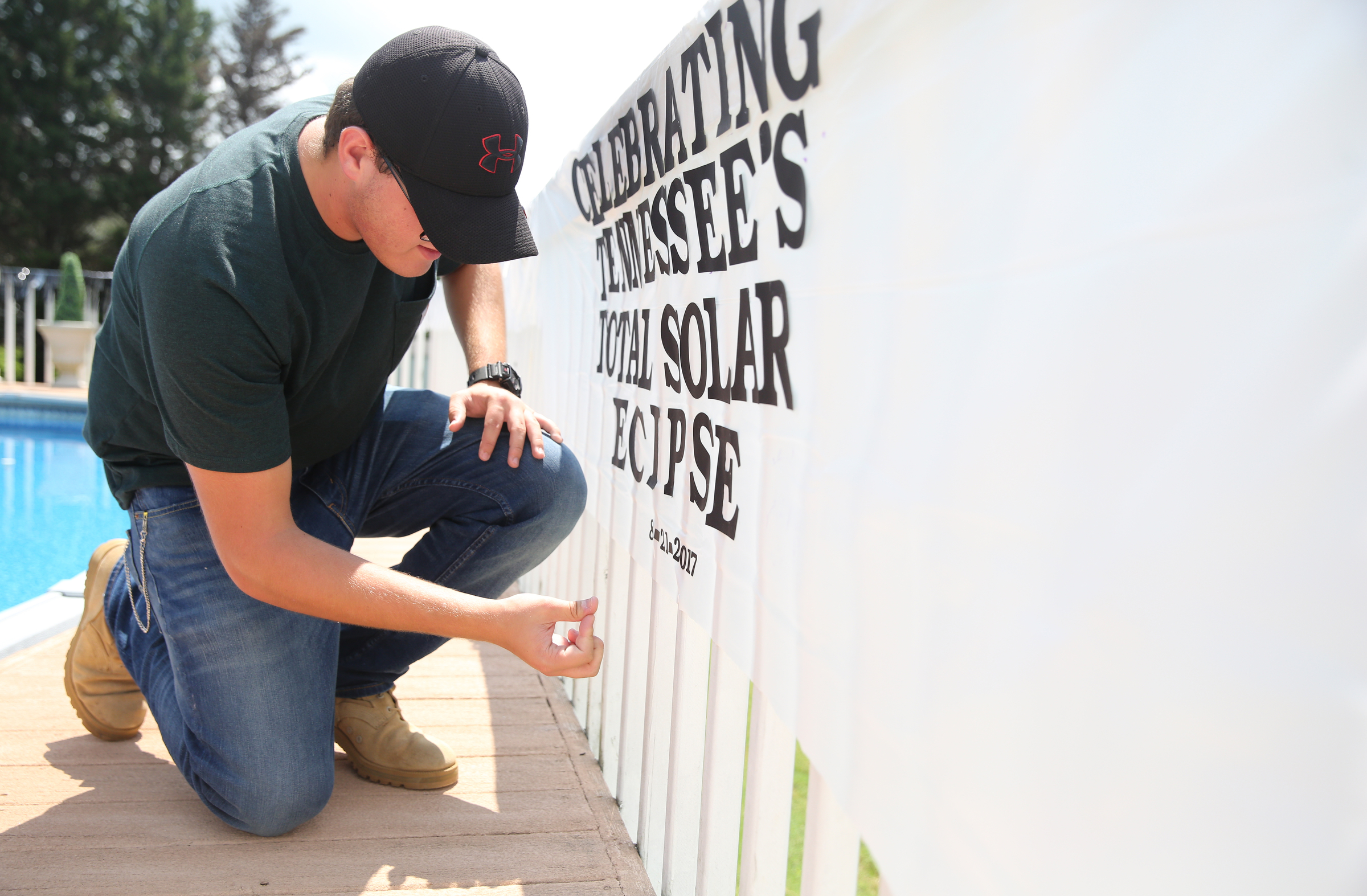 Matthew Burkhart, 16, puts up a banner at his grandparents' house Tuesday, Aug. 8, 2017, in Soddy-Daisy, Tenn. Burkhart, his cousins and grandmother were preparing decorations and souvenirs for guests who attend their Great American Eclipse party next week.