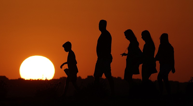 
              FILE - In this July 21, 2016 file photo, the sun sets beyond visitors to Liberty Memorial  as the temperature hovers around 100 degrees in Kansas City, Mo. A new U.S. report says last year’s weather was far more extreme or record breaking than anything approaching normal.
The National Oceanic and Atmospheric Administration on Thursday, Aug. 10, 2017, released its annual state of the climate 2016 report, highlighting numerous records including hottest year, highest sea level and lowest sea ice in the Arctic and Antarctica. (AP Photo/Charlie Riedel, File)
            