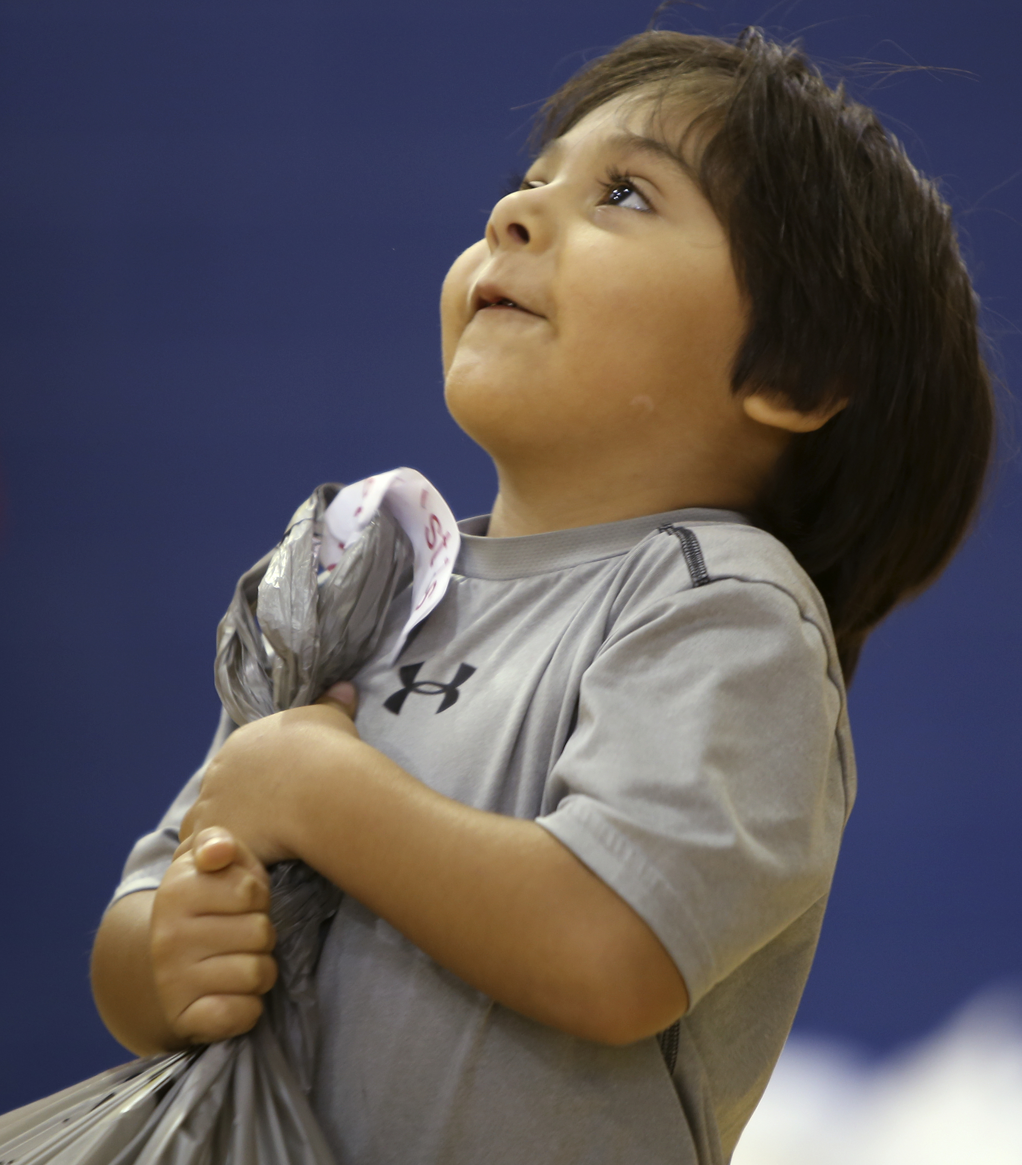 First-grader Kaleb Loera strains to hold up his bag of school supplies at Roan School on Wednesday, Aug. 2, in Dalton, Ga. Roan School, a low-income school, held their orientation on Wednesday and school supplies that were collected and donated by Rock Bridge Community Church were passed out.
