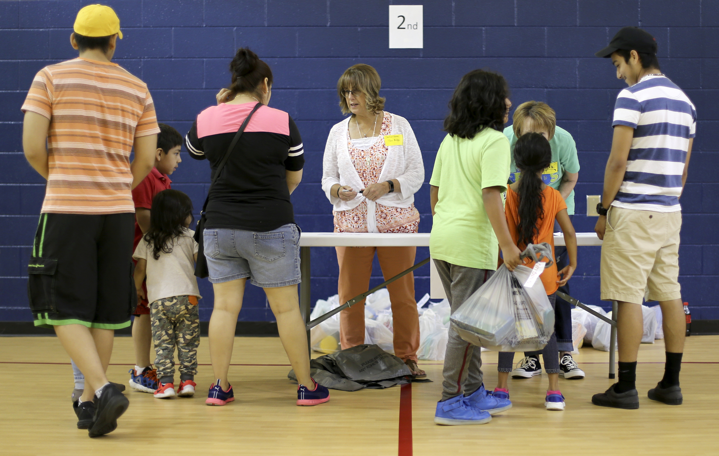 People pick up bags of school supplies for second graders at Roan School on Wednesday, Aug. 2, in Dalton, Ga. Roan School, a low-income school, held their orientation on Wednesday and school supplies that were collected and donated by Rock Bridge Community Church were passed out.