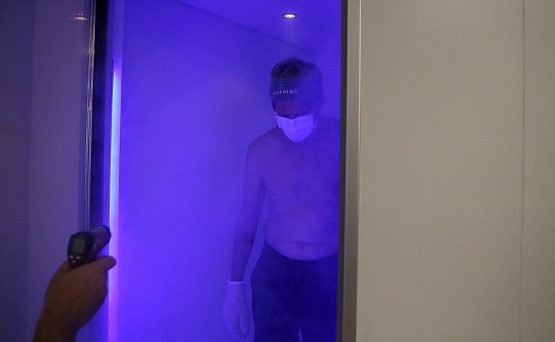 Chattanooga marathon runner Steve Rogers leaves the cryotherapy chamber, as Alternative Medicine Consultant Bret Moldenhauer [CQ] prepares to take his temperature, at Norspring Center for Rejuvenation on Friday, Aug. 11, in Chattanooga, Tenn.