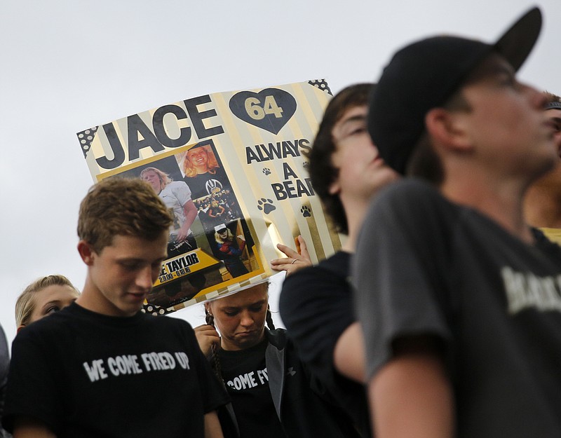 The Bradley Central student section holds signs for former football player Jace Taylor, who died of a drug overdose, during their prep football game against Walker Valley at Bradley Central High School on Thursday, Aug. 18, 2016, in Cleveland, Tenn.