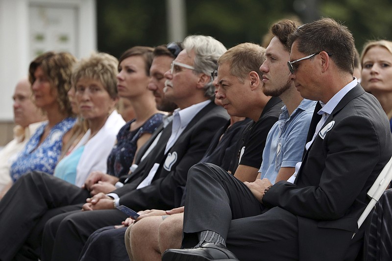 
              Don Damond, right, sits with family and friends during the memorial service for Justine Damond, Friday, Aug. 11, 2017, at Lake Harriet in Minneapolis. Damond was killed by a Minneapolis police officer on July 15 after she called 911 to report a possible sexual assault near her home.  (Anthony Souffle/Star Tribune via AP)
            